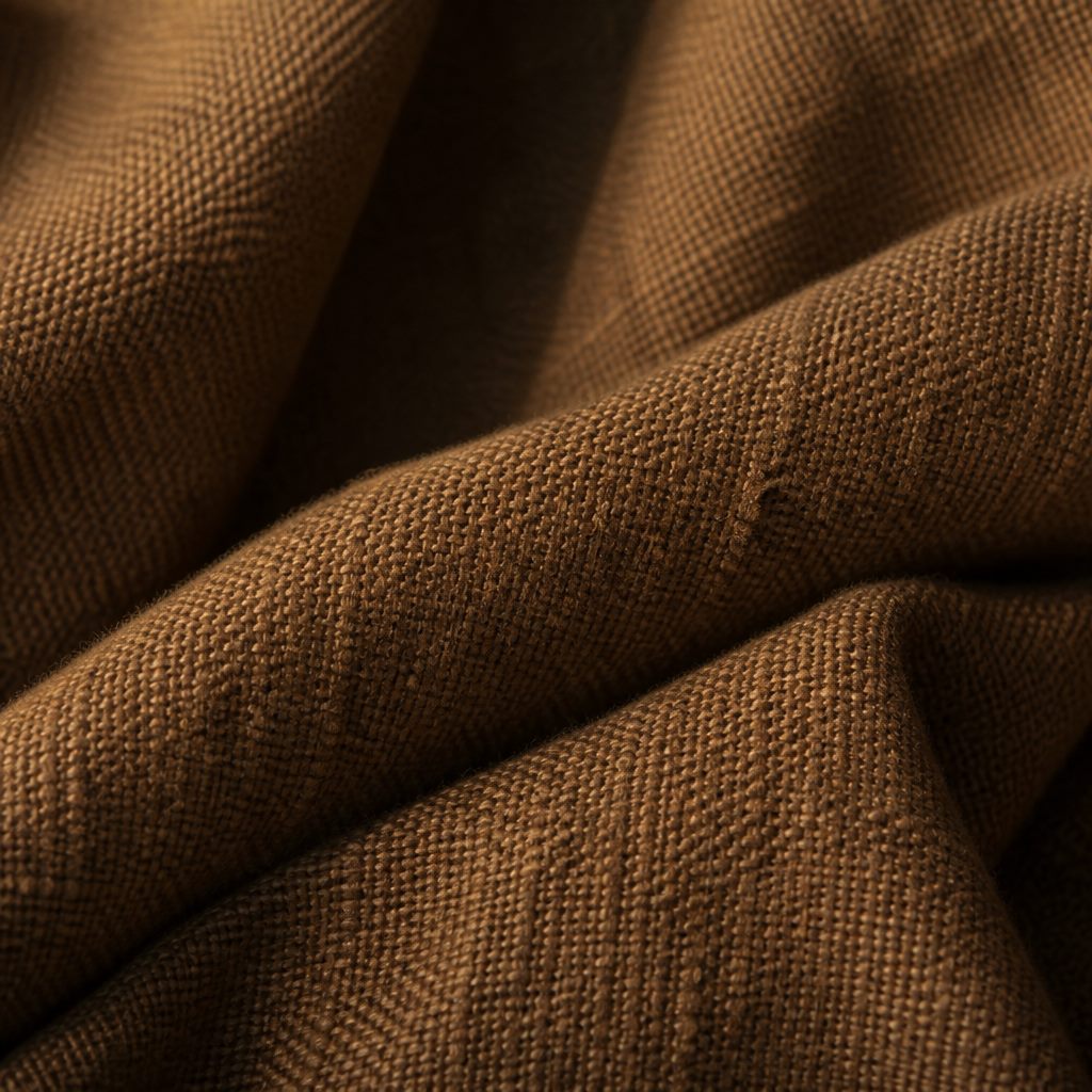 Macro texture of handwoven khaddar fabric in warm earthy brown