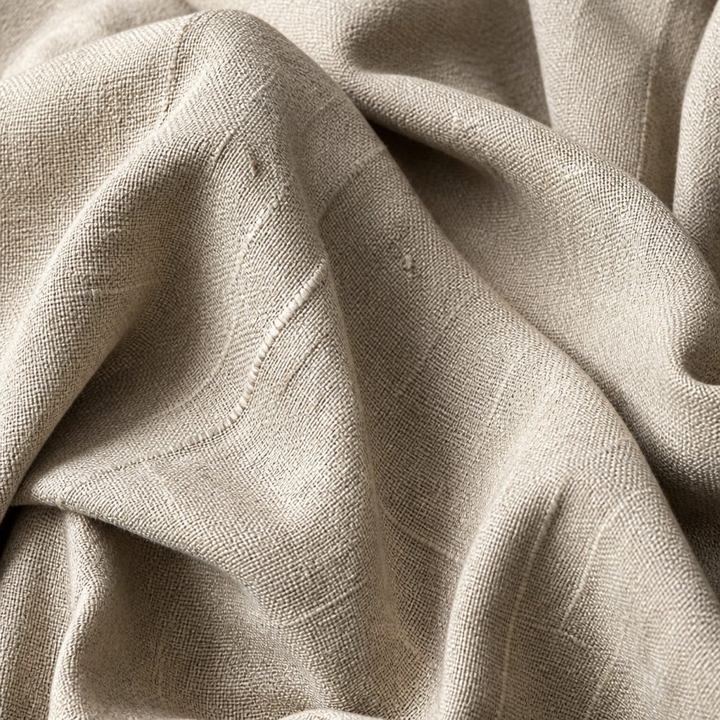 Macro texture of slubbed natural linen fabric in soft stone tone